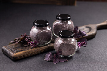 Jars of purple basil salt on wooden board