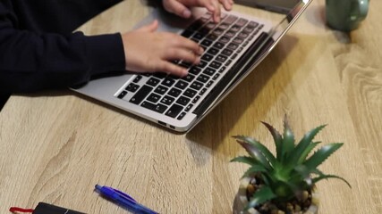 Young student's hands typing on a modern laptop computer, representing online education, cybersecurity for kids, and the digital dangers children face while browsing the internet at home - Powered by Adobe