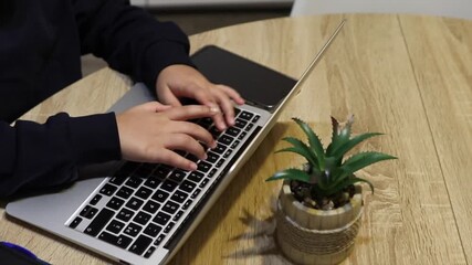 Young boy's fingers typing on a laptop keyboard during online learning, representing digital education, cybersecurity awareness, and children's safety and wellbeing in a connected world - Powered by Adobe