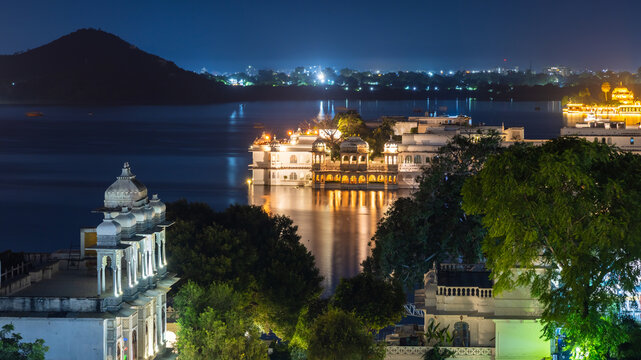Aerial night time view of city palace and lake palace in Lake Pichola in Udaipur, Rajasthan, India, known for its beautiful lakes and palaces.