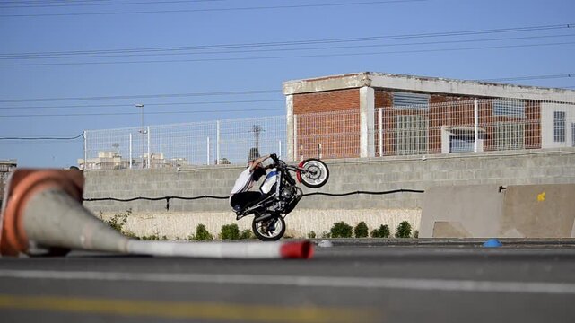 Motorcycle Stunt Rider Doing Wheelies and Acrobatics on Track
