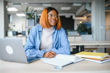african american girl student studying at university at desk. Concept of higher education