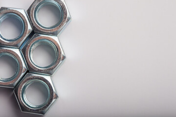 Assorted steel hex nuts on white background for industrial hardware supply and mechanical engineering. Various sizes of metallic fasteners for bolt security construction and technical assembly