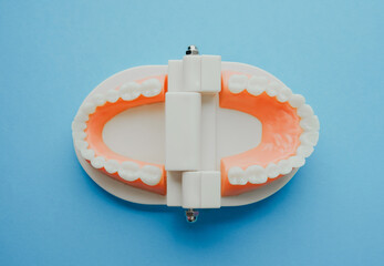 Dental implant model with surgical guides on a clean blue background, top view, close up