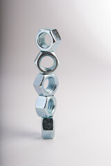 Hexagonal steel nuts macro industrial hardware group for mechanical engineering and construction projects. Close-up of silver metallic fasteners used for secure bolt connection and assembly