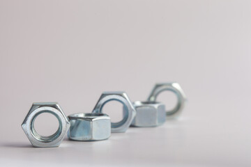 Steel hex nuts stack tower on white background for industrial business concept and construction balance. Vertical row of metallic fasteners representing strength stability and engineering precision