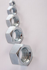 Steel hex nuts stack tower on white background for industrial business concept and construction balance. Vertical row of metallic fasteners representing strength stability and engineering precision