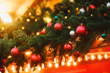 Christmas evergreen garland with vibrant red silver baubles and warm glowing fairy lights bokeh