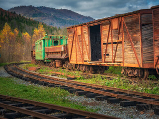 view to old wagons and lines on abandoned rail station in mountains