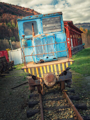 face view to old locomotive on rail in museum under open sky