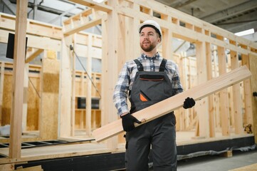 Fototapeta premium A carpenter works on the construction of modular houses