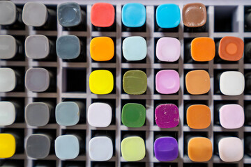 Rack of colourful art supplies close up background