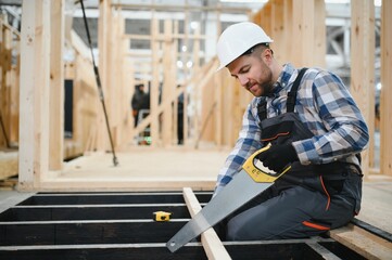 Fototapeta premium Worker carpenter assembling a modular house