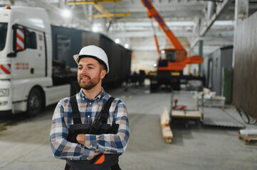 A worker controls the process of loading a modular house onto a truck. Transportation and delivery concept