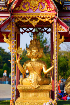 Golden four-faced Brahma statue enshrined on a ceremonial float at Wat Tha Ton, a modern hilltop buddhist temple in Mae Ai District, Chiang Mai Province, Northern Thailand