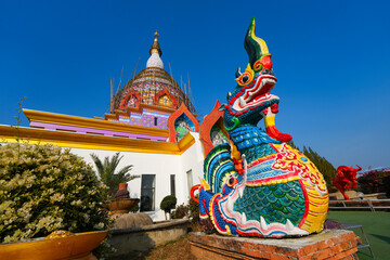 Colorful mythical Naga statue in front of the crystal pagoda of Wat Tha Ton, a modern hilltop buddhist temple in Mae Ai District, Chiang Mai Province, Northern Thailand