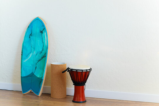 life style equipment for hobby and yoga activity darbuka percussion music instrument and board for balance standing in empty light calm room indoor space white wall advertising background