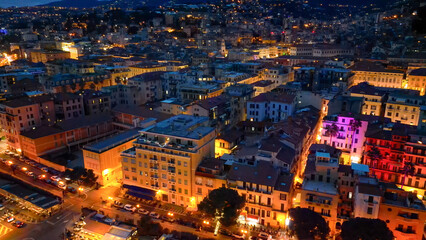 Aerial view of Sanremo at night, Italy. Port and city buildings