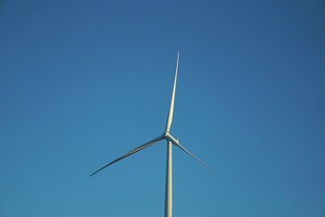 Fototapeta premium White Wind Turbine in a Very Blue Sky
