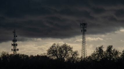 Industrial cell towers stand tall against a gathering winter storm