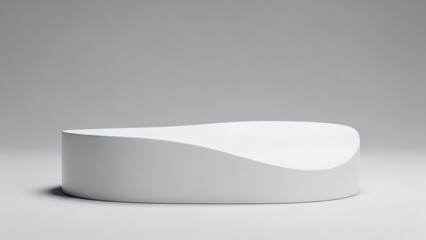 A smooth white elongated platform with a gracefully undulating top surface rests on a light grey ground against a soft grey backdrop