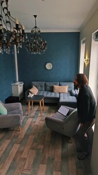 timelapse of bored man in modern cozy living room waiting impatiently accelerating movements as he walks around room paces quickly sits on sofa then armchair changes positions repeatedly fidgets and