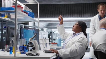 Diverse researchers in lab workspace conducting experiments and analyzing DNA element in jars. Biotechnology, genetics and chemistry tools highlight innovation. Molecular biology.