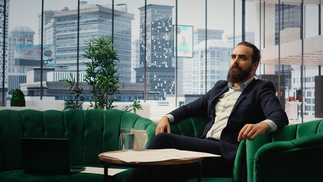 Male entrepreneur studying investments on a hologram illustration, using holography technology for productivity in smart office corporation. Boss looks at holographic image. Camera A.