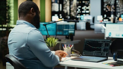 Worried finance advisor seeing the forex trends downward and losing money, concerned about failure and bankruptcy late at night. Frustrated sad person being displeased and stressed.