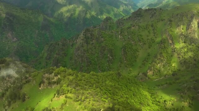 aerial footage showcasing the stunning natural beauty of the Kara-Syrt mountain ridge in Dagestan, Russia. The video captures the vibrant green slopes, rugged terrain, and majestic scale of the Caucas