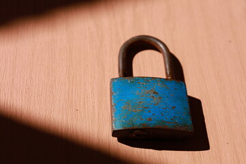 Fototapeta premium an old blue padlock on the wooden surface