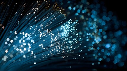 Close-up fiber-optic strands emitting blue light dark technology network data communication innovation speed glow abstraction