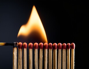 premium photo of close up of lit matchstick with flame among unlit matches on dark surface