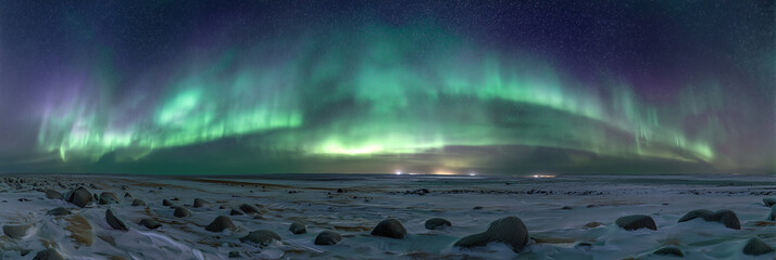 Northern Lights dance across clear night sky in 360 degree panorama. Vibrant green, subtle purple aurora borealis light up vast snowy tundra landscape. Scattered rocks dot cold arctic winter ground