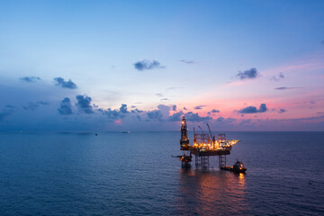 Aerial view of offshore jack up rig in a shipyard during sunset for oil and gas exploration and production.
