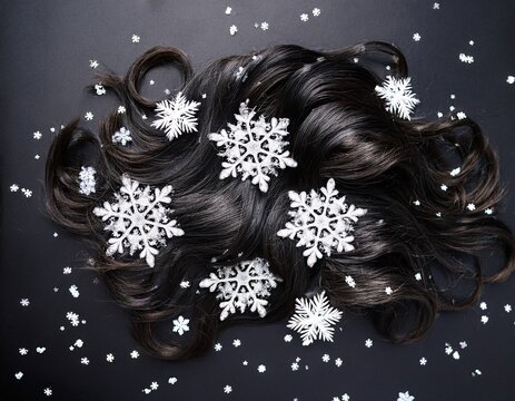 top down view of dark curly hair covered in white flakes on a black background