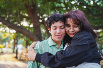 Fototapeta premium Young couple sharing tender hug in green park