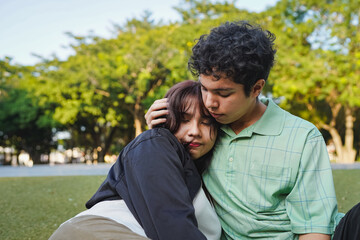 Fototapeta premium Young couple embracing in park showing tenderness and love