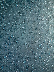 Water droplets on blue waterproof fabric texture background, hydrophobic textile technology concept. Blue background