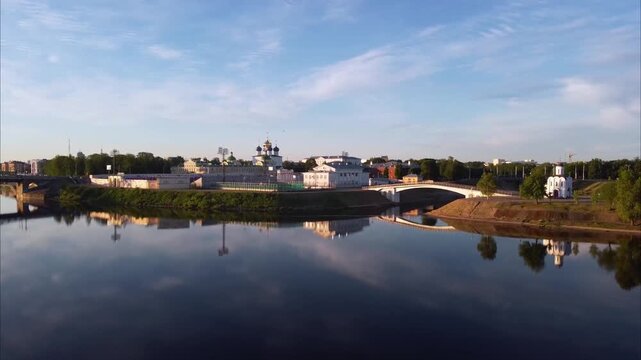 A drone flies over the Volga River in Tver. As it gains altitude, views open up to a church, a cathedral, the city stadium, and the urban landscape.
