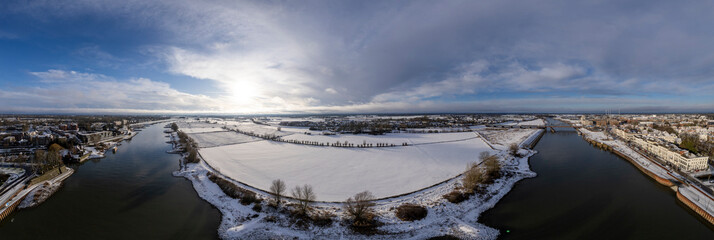 Wide winter wonderland aerial 180 degrees panorama of river IJssel and white floodplains of Dutch Hanseatic medieval tower town Zutphen, The Netherlands. Aerial cityscape after a snowstorm