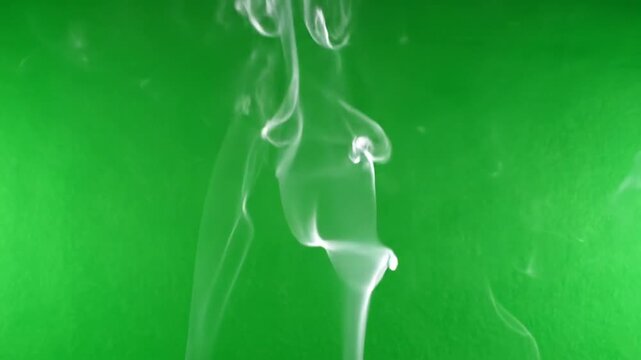 Wispy smoke trails rising against a vibrant green screen background with soft, diffused lighting.