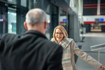Mature woman smiling meeting man at airport