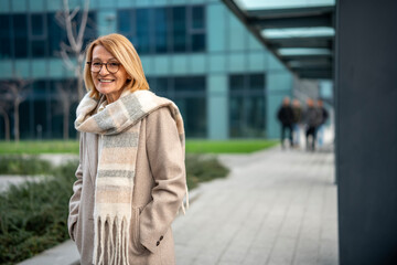 Obraz premium Confident mature business woman smiling in urban setting