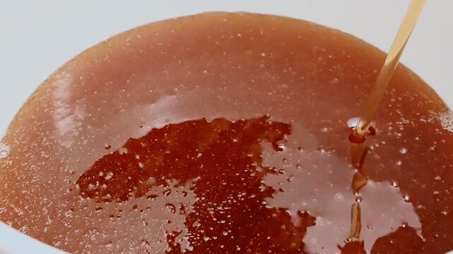 Filling a bucket with fresh harvested honey