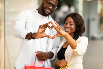 Romantic Relationship Concept. Portrait of happy smiling black African American couple making heart...