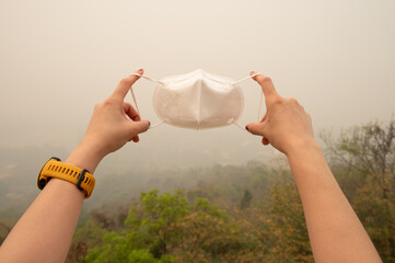 Cropped shot of someone holding a mask for prevent bad air pollution. Air quality masks equivalent to N95, KN95, and FFP2 help provide protection from both PM2. 5 and COVID-19 aerosols.