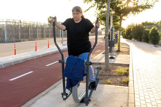 Woman exercising on outdoor elliptical trainer for fitness