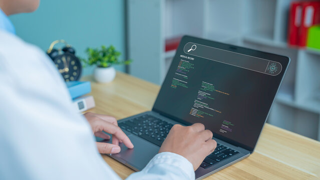 A close-up image of a programmer's hands typing code on a laptop in a modern healthcare workspace, depicting software development, programming, healthcare tech startups, cybersecurity, and digital inn