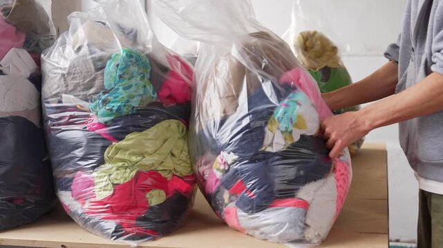 Bags full of used clothing ready for sorting and textile recycling. Sustainable fashion concept, reuse of garments, eco friendly lifestyle, circular economy and waste reduction